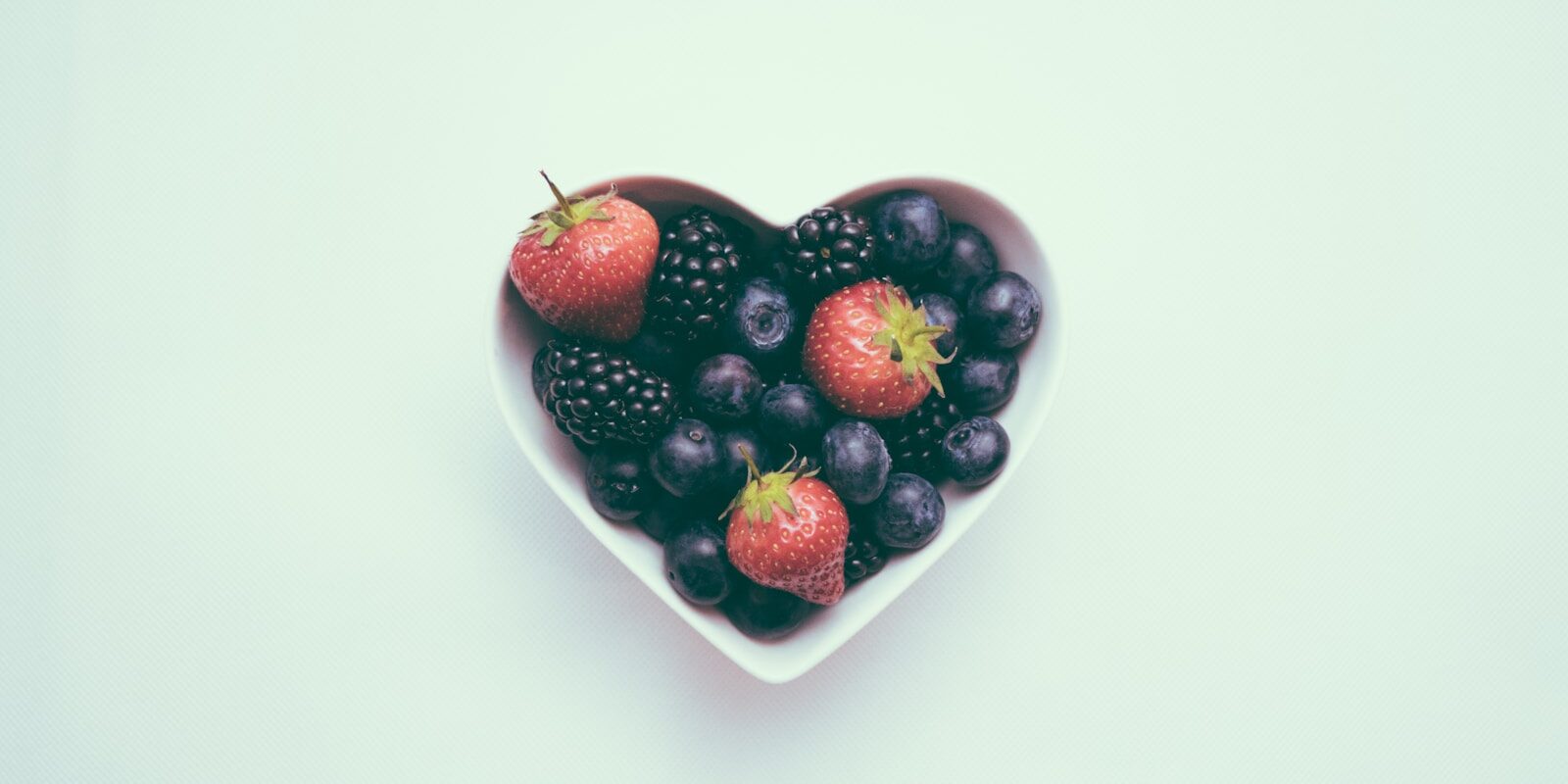 heart-shaped bowl with strawberries